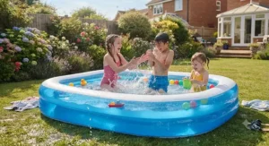 Young children splashing and playing happily in a blue family paddling pool in the back garden