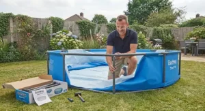 A parent assembling a Best Steel Pro pool in a garden, demonstrating ease of setup