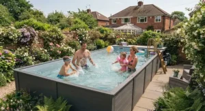 A family playing in a large rectangular above ground pool during a sunny British summer day.
