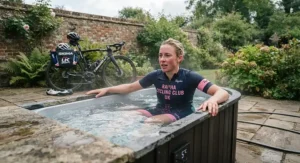 Cyclist utilizing a cold plunge pool for recovery after a long-distance road training ride in Britain