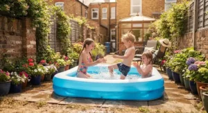 Children splashing in a shallow, rectangular inflatable pool designed for small outdoor garden spaces during a heatwave.