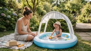 A parent supervising closely next to a baby pool with canopy for newborns on the patio.