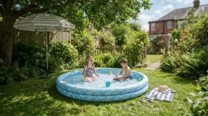 A baby pool with canopy set up on a lawn in a back garden during a warm sunny afternoon