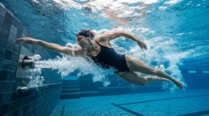 A swimmer training against an adjustable resistance jet in a domestic swim current pool