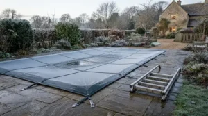 A winterised pool cover and ladder set protecting a garden pool during colder months